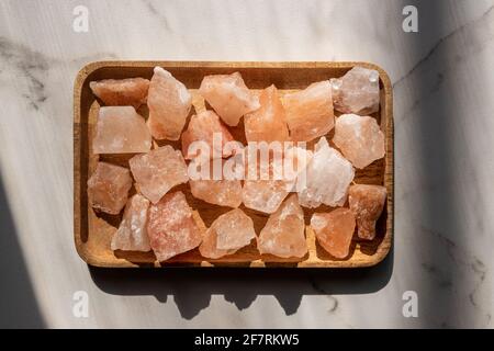 Crystals of Pink himalayan salt on wooden tray, interior deoration, spa and heath care concept. Stock Photo