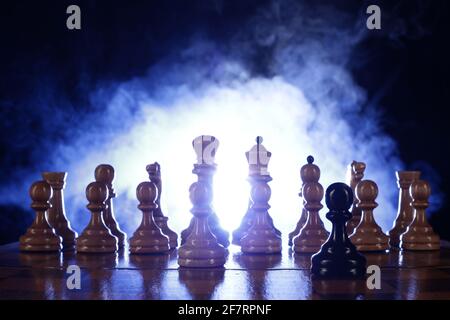 Chess is a board game. Chess pieces on a dark background in smoke Stock Photo