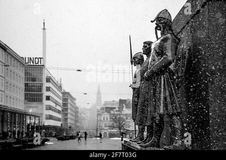 Snowy weather over three of the statues at Sailor's Monument at Torgalmenningen square in downtown Bergen, Norway. Stock Photo