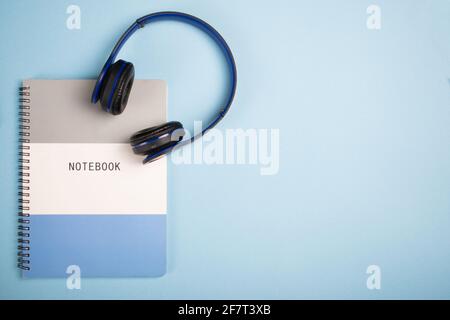 Notebook and headphones on a blue surface - copy space Stock Photo