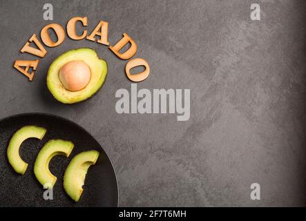 Avocado on gray background - Persea americana 'Hass' Stock Photo