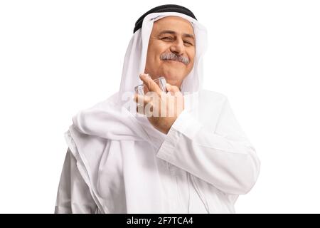 Arab man in white dishdasha spraying a perfume isolated on white background Stock Photo