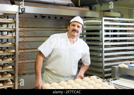 Male Baker Baking Fresh Bread In The Bakehouse Stock Photo, Picture and  Royalty Free Image. Image 12443418.