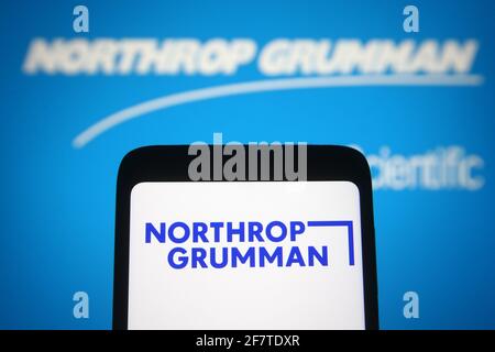 In this photo illustration a Northrop Grumman logo of an US aerospace and defense company is seen on a smartphone and a pc screen. Stock Photo