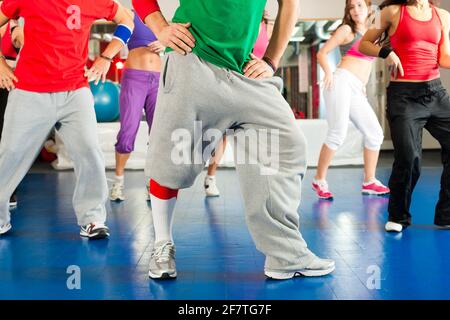 Fitness - Young people doing Zumba training or dance workout in a gym Stock Photo