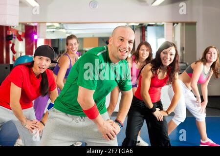 Fitness - Young people doing Zumba training or dance workout in a gym Stock Photo