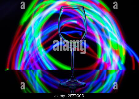 wine glass against the background of colored bright stripes Stock Photo