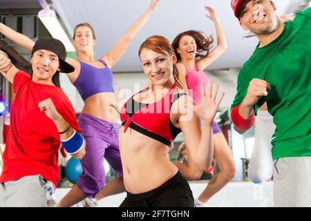 Fitness - Young people doing Zumba training or dance workout in a gym Stock Photo