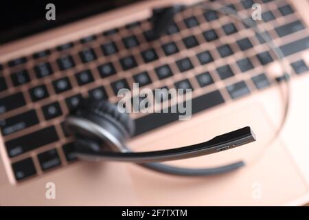 Black head set lying on laptop keyboard closeup Stock Photo