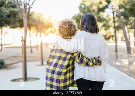 Happy African-American and Caucasian female friends hugging each other - multiracial friendship Stock Photo
