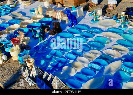 A display of traditional Egyptian souvenirs in beautiful blue color dominant on the pavement waiting for tourists. Aswan Egypt. Stock Photo