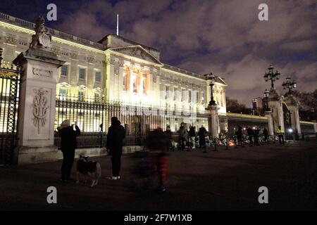 Rip prince Philip everyone was saying outside Buckingham Palace until late last night. There was a lot of people there leaving  flowers at the gates and someone left a teddy bear also.a lot of police as well and they arrested a guy for shouting and being drank .another guy was holding to candles and was trying to get a selfie of himself as well. Some people were crying and a lot of people were walking around the palace. here was a lot of traffic as well .usually you do not get that much traffic outside the palace at this time of the day.the flag was a half mast Stock Photo