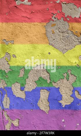 Rainbow colored LGBT pride flag painted on an old and weathered concrete wall, paint is peeling off. Textured background of a colorful concrete wall. Stock Photo