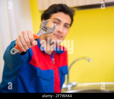 The plumber repairing tap at kitchen Stock Photo