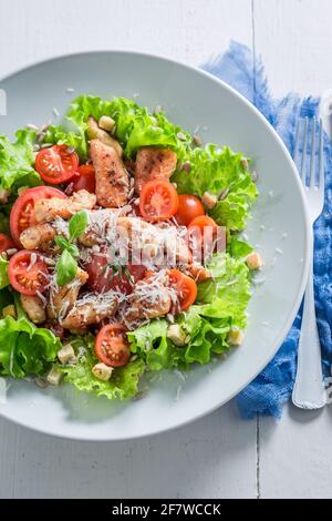 Caesar salad made of chicken, cherry tomatoes and parmesan. Greek cuisine. Stock Photo