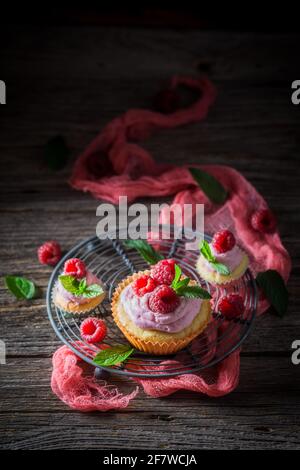 Raspberry muffin with cream and fresh fruits. Vanilla cupcake with fruit. Homemade sweets. Stock Photo