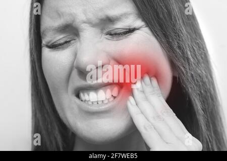 Close up of woman face with tooth pain and painful expression. Woman suffering from toothache. Female feeling tooth pain Stock Photo