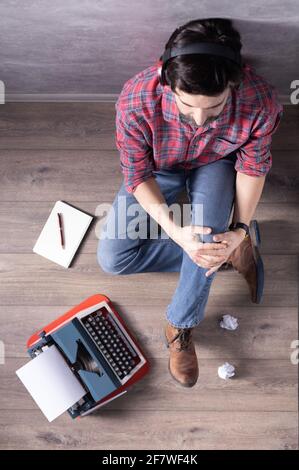 Man sitting on floor thinking idea. Student man relaxing with music headphones. Creative inspiration concept Stock Photo