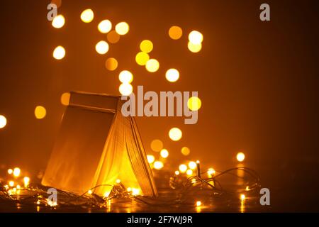 Old book on table against blurred lights Stock Photo