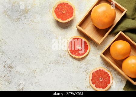 Boxes with ripe grapefruits on light background Stock Photo