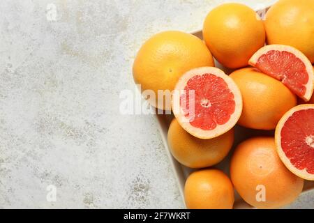 Box with ripe grapefruits on light background Stock Photo