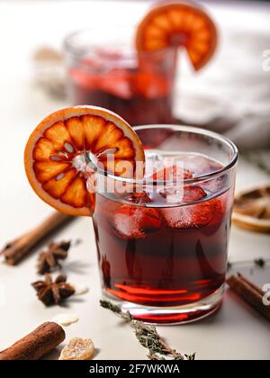 Cold mulled wine with cherry and bloody orange. Vertical shot. Close-up. Alcoholic beverage still life.