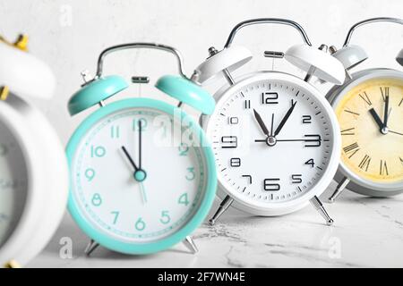 Different alarm clocks on light background, closeup Stock Photo