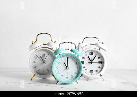 Different alarm clocks on light background Stock Photo