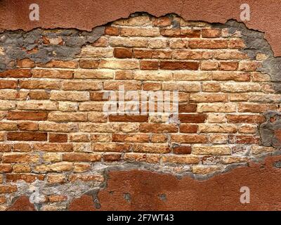 Horizontal part of Old Venetian red brick wall with devastating bricks Stock Photo