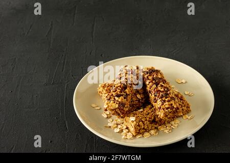 homemade granola energy bars with almond and raisins on black background. Healthy food. Stock Photo