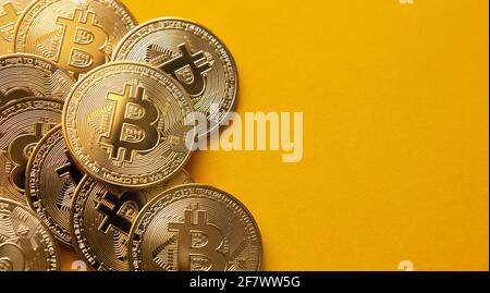 Close up shot of some bitcoins on a yellow background and copy space. Golden BTC coins, Stock Market of cryptocurrencies and decentralized finances co Stock Photo