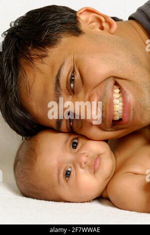 Portrait of indian happy father and six months old baby girl spend time together hugging and cuddling smiling father embrace cute little child Stock Photo