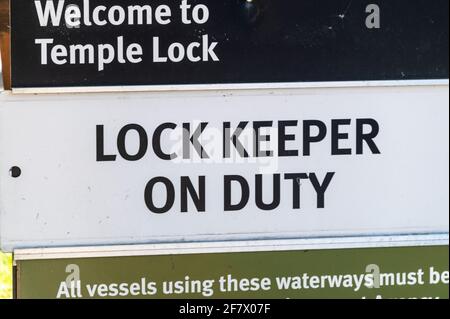 A large notice informing boat crews – ‘Lock Keeper on Duty’ at Temple Lock, between Hurley and Marlow on the River Thames in Buckinghamshire, Britain. Stock Photo