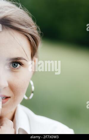 Half face close up of young beautiful smiling girl with round big earrings. Place for your text. Stock Photo