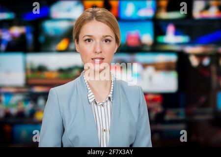 An anchorwoman reporting live breaking news sitting in Tv studio