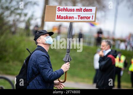 10 April 2021, Baden-Wuerttemberg, Heilbronn: 'Stop the mask terror!' is written on the sign of a participant of a demonstration of the initiative 'Querdenken'. The demonstration is directed against the pandemic restrictions of the federal government. Photo: Christoph Schmidt/dpa Stock Photo