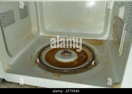 very dirty inner surface microwave after spilled sweet coffee Stock Photo