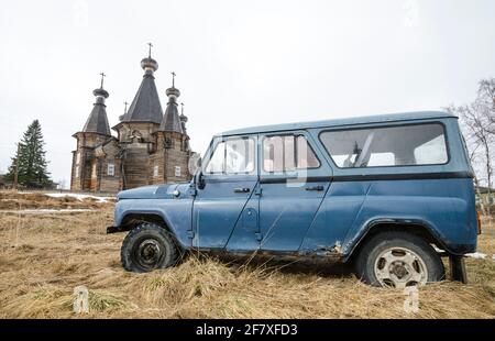 April, 2021 - Nyonoksa. Old Russian rusty cars on the background of wooden Orthodox churches. Russia, Arkhangelsk region Stock Photo