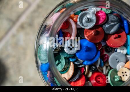 various types of buttons stored in a glass container Stock Photo