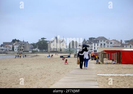 Frankreich, Le Pouliguen, 28.06.2020: ein Paar mit Regenschirm bei Nieselwetter am Strand von Le Pouliguen an der franzoesischen Atlantikkueste im Dep Stock Photo