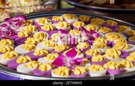 white and purple deviled eggs served on a plate at a party Stock Photo