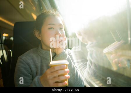 train travel getaway - lifestyle portrait of young happy and beautiful Asian Japanese woman traveling on railway looking through window Stock Photo