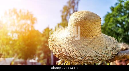 Straw hats in sunshine on a heap for sale. Stock Photo