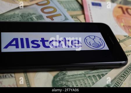 Viersen, Germany - March 1. 2021: Closeup of smartphone with logo lettering of allstate insurance company on paper money currency Stock Photo