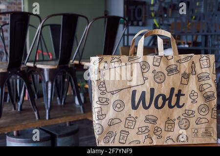 Wolt food delivery bag with company logo, on restaurant. Finish company paper bag with handle, used by platform courier partners. Stock Photo