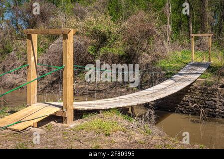 Swinging footbridge on the Jean-Pierre Choteau Nature Trail along the Neosho (Grand) River at Clinkenbeard Park in Fort Gibson, Oklahoma. (USA) Stock Photo