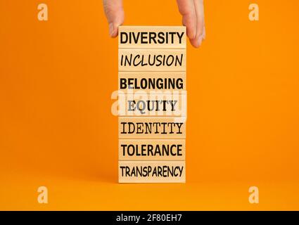 Diversity belonging inclusion equity identity tolerance transparency words written on wooden block. Male hand. Beautiful orange background. Diversity, Stock Photo