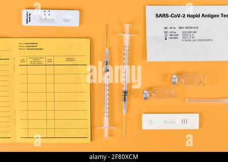 Concept for lift of restrictions for people with corona virus vaccination or negative test with certificate of vaccination, travel passport, syringe, Stock Photo