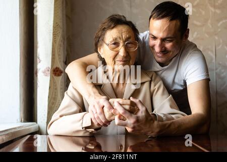 a very old woman and an adult grandson Stock Photo