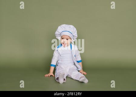 Portrait of a little boy cook holding pan at the kitchen. Different occupations. Isolated over white background. Twin brothers Stock Photo